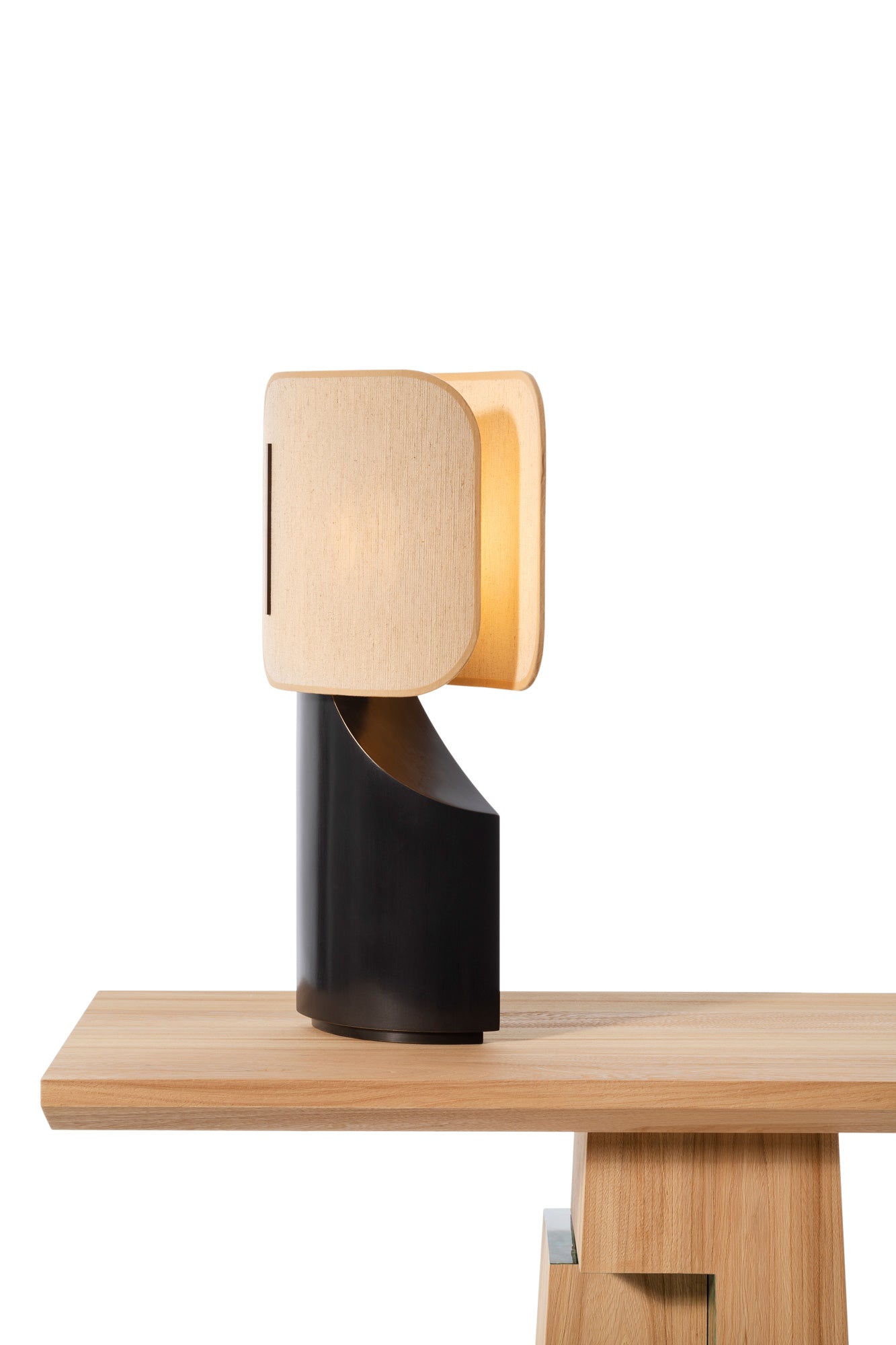 Lampe Ibiza allumé en bronze et abat-jour en tissu posé sur une console Etretat en bois d'orme brossé sur fond blanc