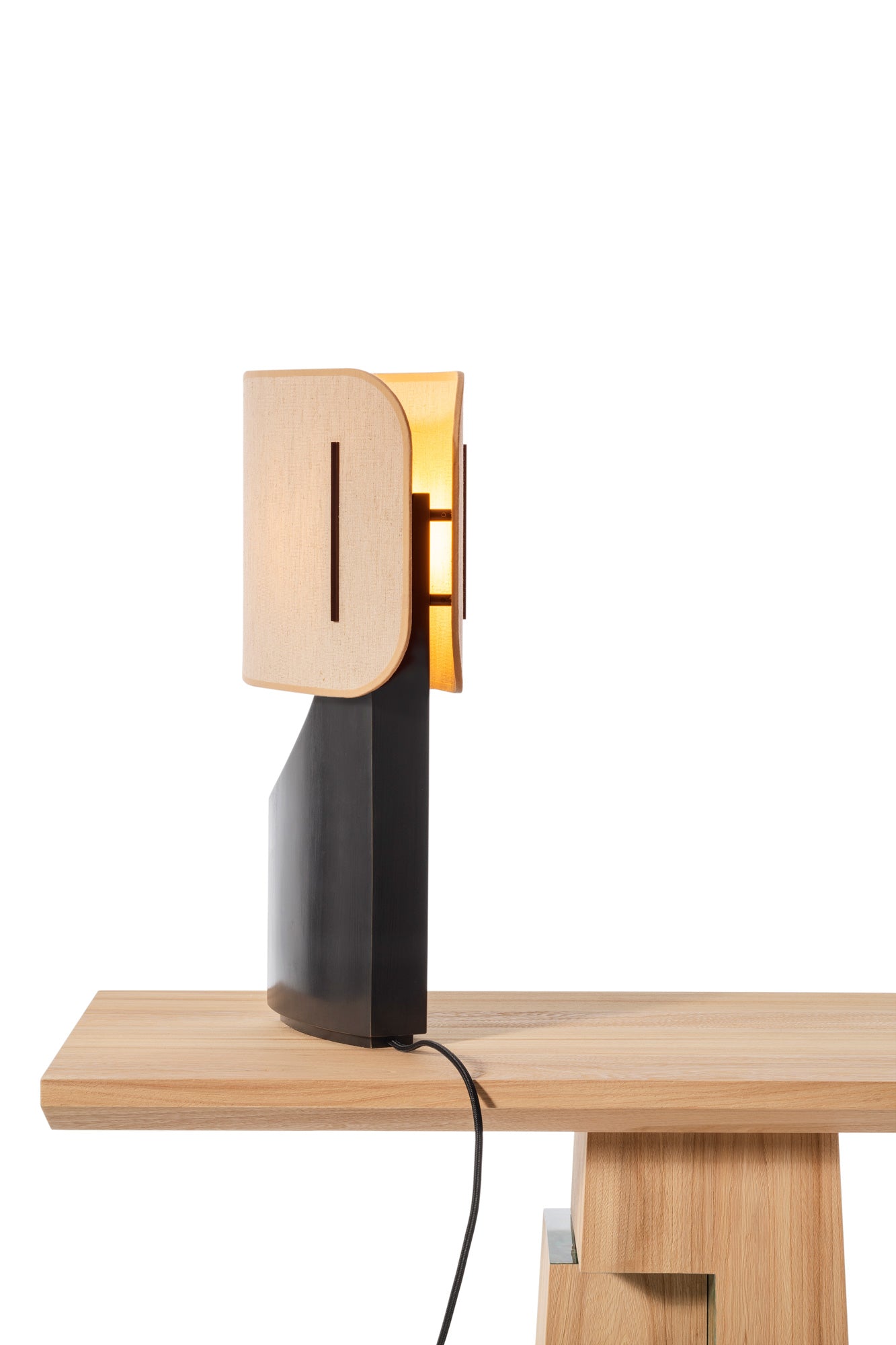 Lampe Ibiza allumé en bronze et abat-jour en tissu posé sur une console Etretat en bois d'orme brossé sur fond blanc